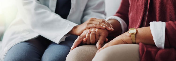 A healthcare professional holding a patient's hand