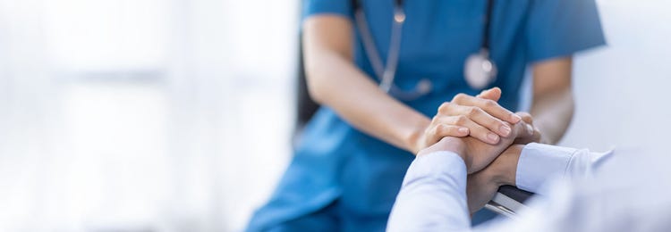 Healthcare professional holding a patient's hands
