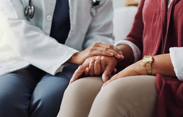 A healthcare professional holding a patient's hand