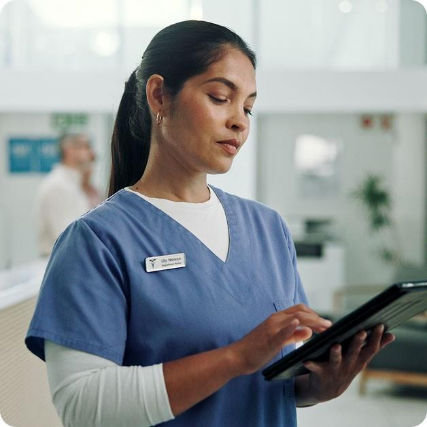Nurse in blue scrubs using a tablet